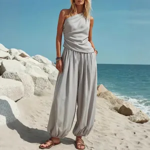 Volledig overzicht van de dames set met one-shoulder top en pofbroek op een zonnig strand