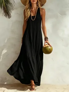 Elegant woman in black sleeveless boho maxi dress holding a coconut on a beach backdrop.