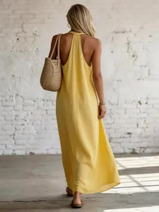 Back view of a yellow sleeveless backless linen maxi dress for a summer vacation look.