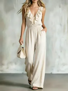 Detail view of cream sleeveless V-neck jumpsuit with elegant ruffle trim and side pockets