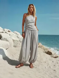 Elegant tweedelig setje met one-shoulder top en losse grijze harembroek voor de zomer