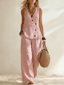Modèle portant un gilet en lin rose et un pantalon large dans une scène de plage.