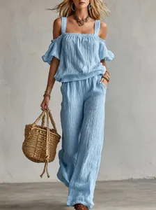 Detail view of the textured light blue off-the-shoulder top and wide-leg trousers set