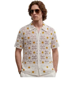 Detail des aufwendigen Gänseblümchenmusters auf einem weißen Häkel-Poloshirt