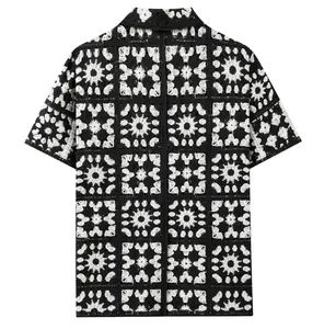 Gedetailleerd overzicht van het vintage etnische haakpatroon op het zwart-witte gebreide poloshirt