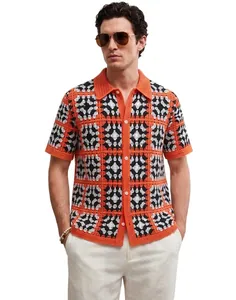 High-quality detail of men's summer crochet knit polo shirt with orange geometric pattern.