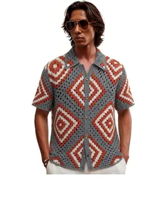 Detail of men's crochet knit shirt with grey and orange diamond geometric pattern.