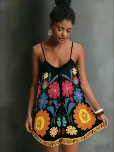 Detail of ethnic style black floral dress with vibrant sunflowers and spaghetti straps
