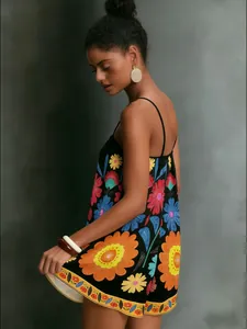 Detail view of vibrant ethnic floral print on a black summer strap dress