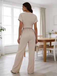 Back view of elegant beige short sleeve wide leg jumpsuit in a bright interior.