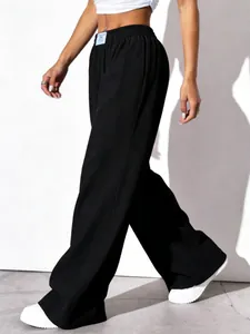 Close-up view of black textured high-waisted wide-leg trousers with pleated fabric
