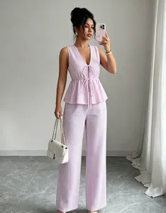 Détail de l'ensemble haut sans manches rayé rose à nouer et pantalon large assorti