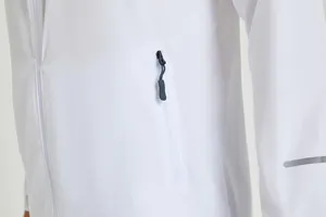 Détail d'un coupe-vent de course blanc avec poche zippée et bande réfléchissante.