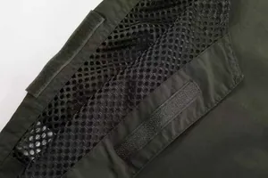 Detailed close-up of breathable mesh lining and Velcro fastener on olive utility vest