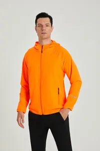 Détail d'une veste de running orange à capuche légère avec bandes réfléchissantes.