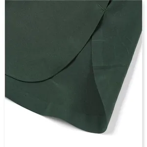 Close-up of the curved hem and fine stitching on dark green quick-dry sports shorts