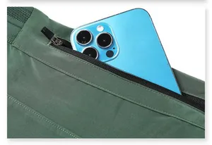 Close-up macro view of green quick-dry sports shorts zipper pocket with a phone