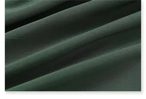 Macro view of dark green breathable quick-dry fabric for men's athletic shorts