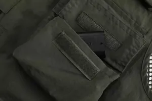 Detailed view of a dark olive green multi-pocket utility vest with Velcro pocket flap.