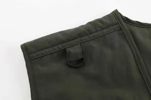 Detailed close-up of army green outdoor fishing vest showing shoulder seam and D-ring