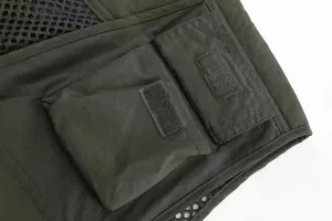 Detail showing multi-pocket cargo design of tactical fishing vest with velcro closures.