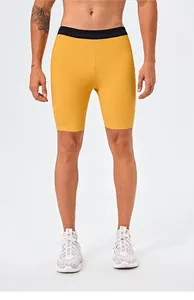 Close-up of men's yellow quick-dry sports shorts showing compression fit and elastic waist