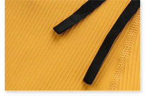 Macro view of yellow quick-dry ribbed fabric and black drawstrings on athletic shorts