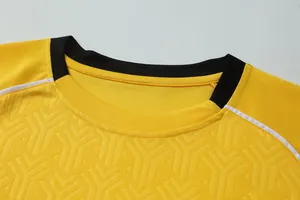 Close-up detail of yellow breathable soccer jersey black collar and textured fabric