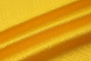 Close-up of premium yellow quick-dry breathable mesh fabric for football jerseys.