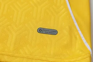 Macro detail of yellow quick-dry soccer jersey with official licensed team product tag