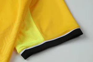 Close-up detail of a yellow breathable soccer jersey sleeve with mesh and black cuff