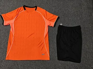 Detail view showing the full orange football jersey and black shorts set flat lay