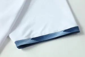 Macro-detail van de mouw van een ademend voetbalshirt met een blauw gestreepte manchet.