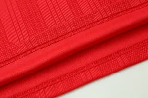Detailed texture of red jacquard fabric on a breathable soccer jersey