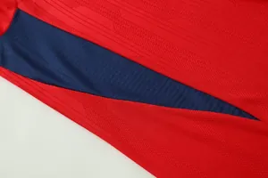 Close-up of breathable jacquard fabric texture on a red and navy soccer jersey.