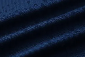 Macro detail of navy blue breathable textured soccer jersey fabric with striped pattern