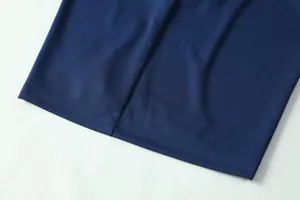 Gedetailleerd macro-zicht op ademende marineblauwe mesh-stof en zoomstiksel op voetbalshirt
