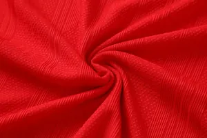 Macro detail of red breathable jacquard fabric for quick-dry soccer jersey training suit