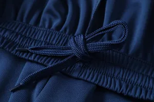 Detailopname van de tailleband met trekkoord van een donkerblauwe voetbalbroek.