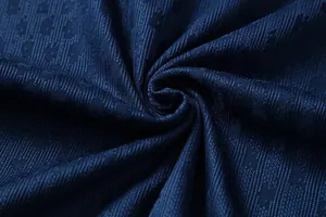 Detailed close-up of navy blue breathable football jersey fabric with textured weave pattern