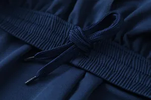 Close-up of breathable jacquard fabric and drawstring on navy blue football kit.