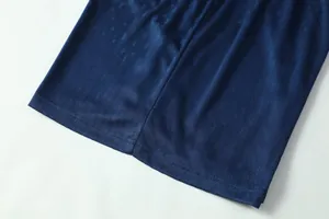 Close-up of breathable navy blue textured fabric detail on the football jersey hem.