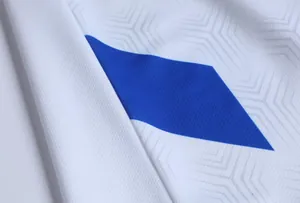 Dettaglio macro del tessuto della maglia da calcio in mesh bianco traspirante con blu