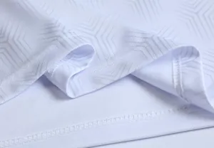 Dettaglio del tessuto della maglia da calcio bianca con trama geometrica e cuciture.