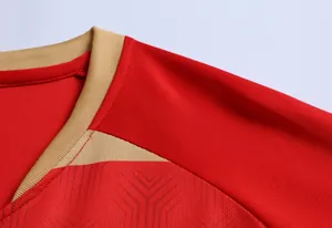 Dettaglio del colletto della maglia da calcio in tessuto mesh traspirante rosso e oro