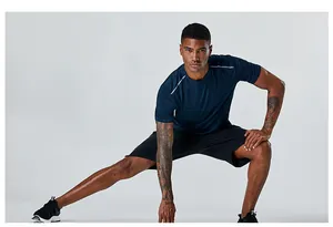 Modèle masculin athlétique s'étirant dans un t-shirt de sport bleu à séchage rapide
