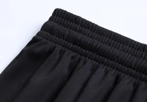 Dettaglio ravvicinato della fascia elastica in vita di pantaloncini sportivi neri traspiranti