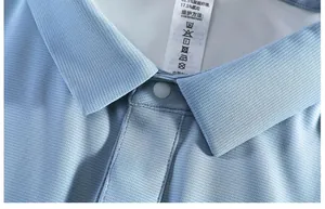 Close-up of light blue polo shirt collar showing breathable mesh fabric texture and tag