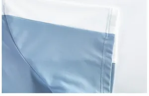 Close-up of quick-dry fabric shoulder stitching on a blue and white sports polo shirt