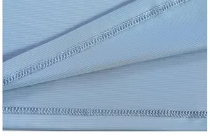 Macro view showing the stitching and mesh texture of a light blue polo shirt